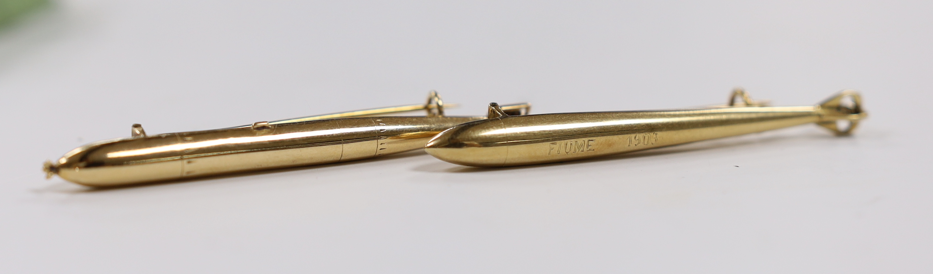 Two early 20th century yellow metal torpedo brooches, one inscribed 'Fiume 1903 Klara', 62mm et infra, 5.6 grams.